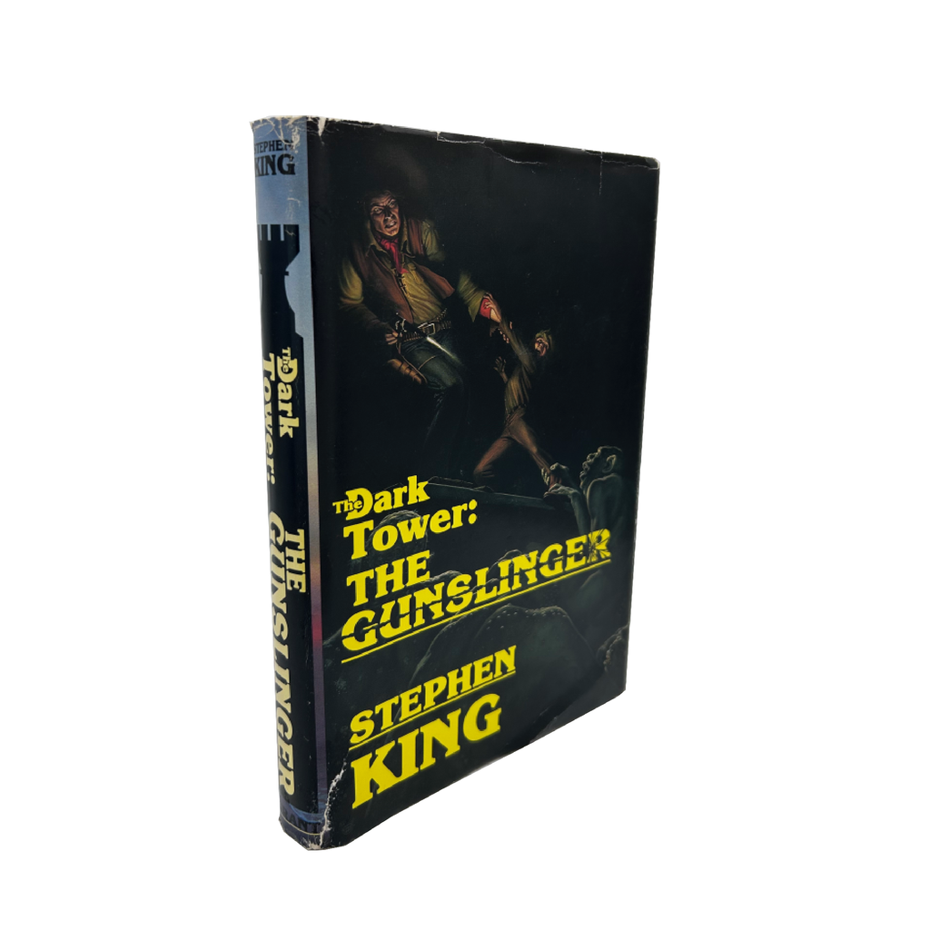 Book titled 'The Dark Tower: The Gunslinger' by Stephen King with a black cover and yellow text.