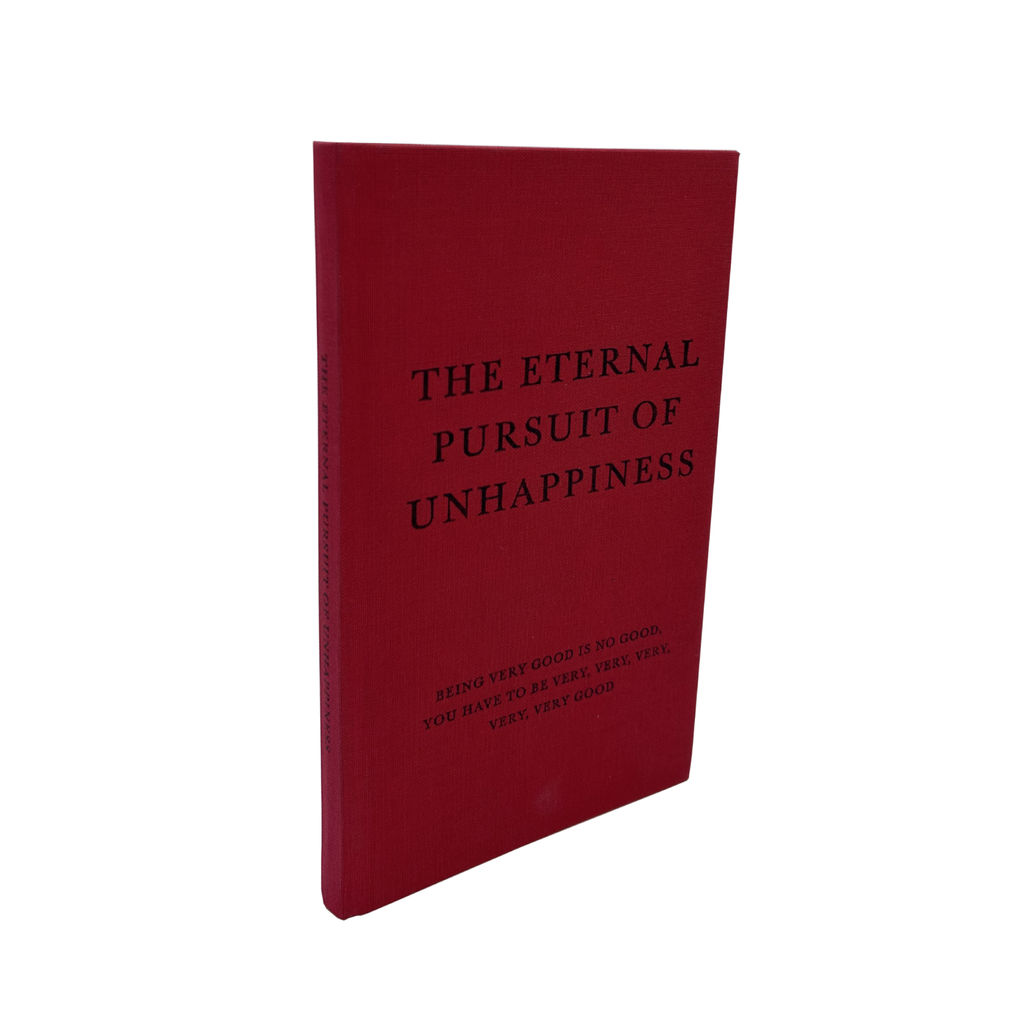Red book titled 'The Eternal Pursuit of Unhappiness' on a white background